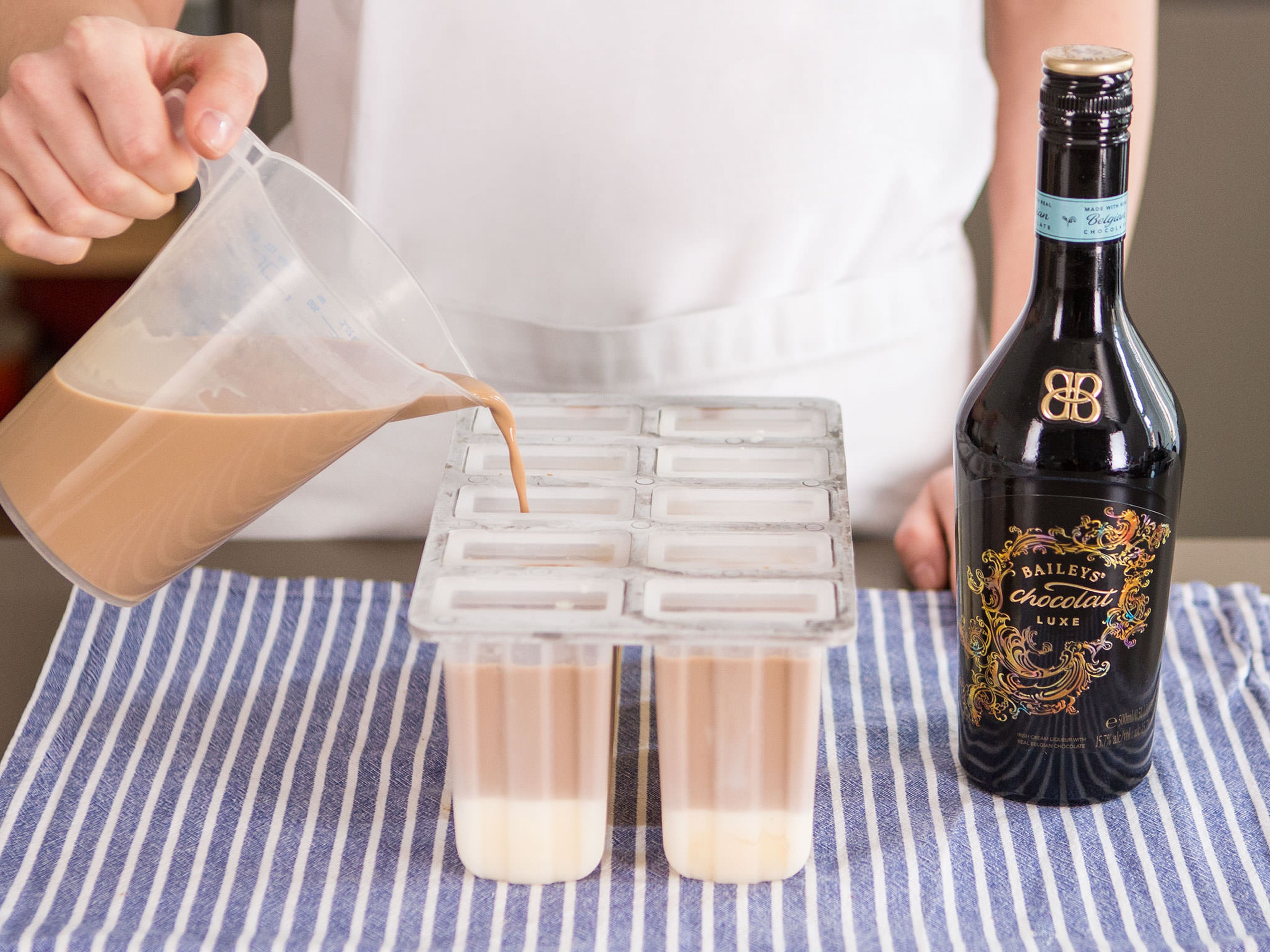 Mix together coffee, Baileys, more of the cream, and rest of the condensed milk mixture. Now, fill each popsicle mold almost to the top with Baileys mixture.