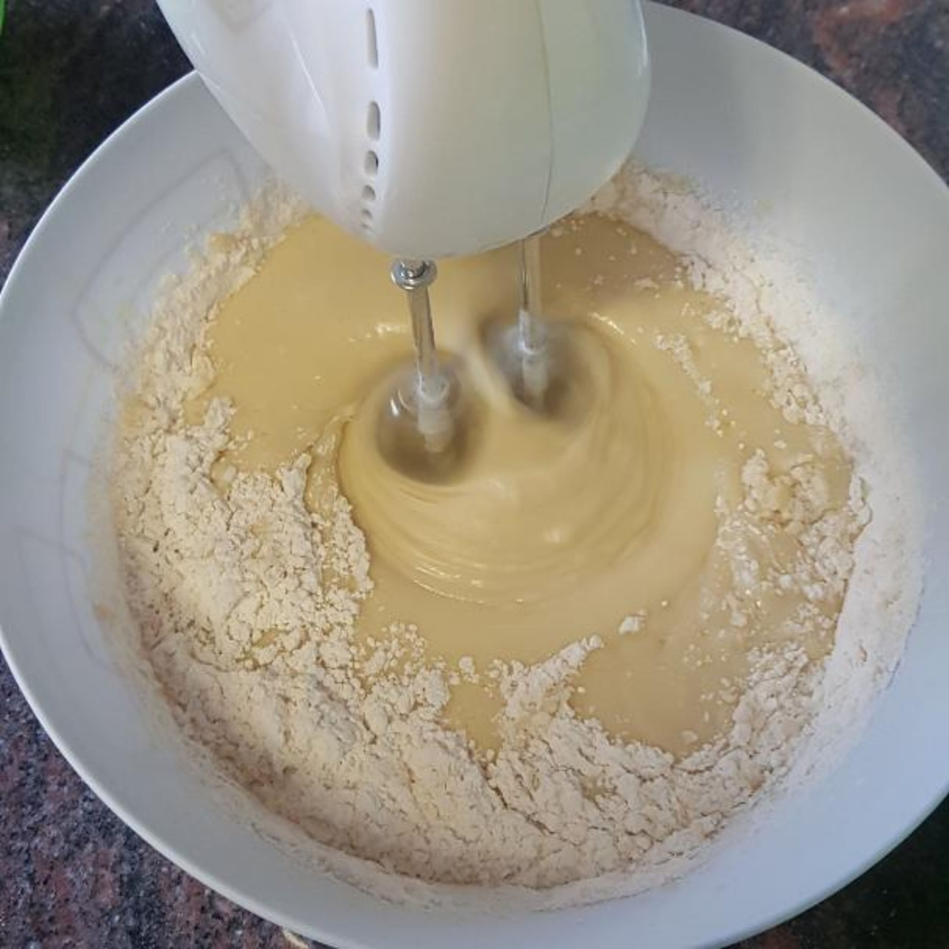 add the flour mixture to the eggs mixture and mix them with the electrical mixer for 1 minute