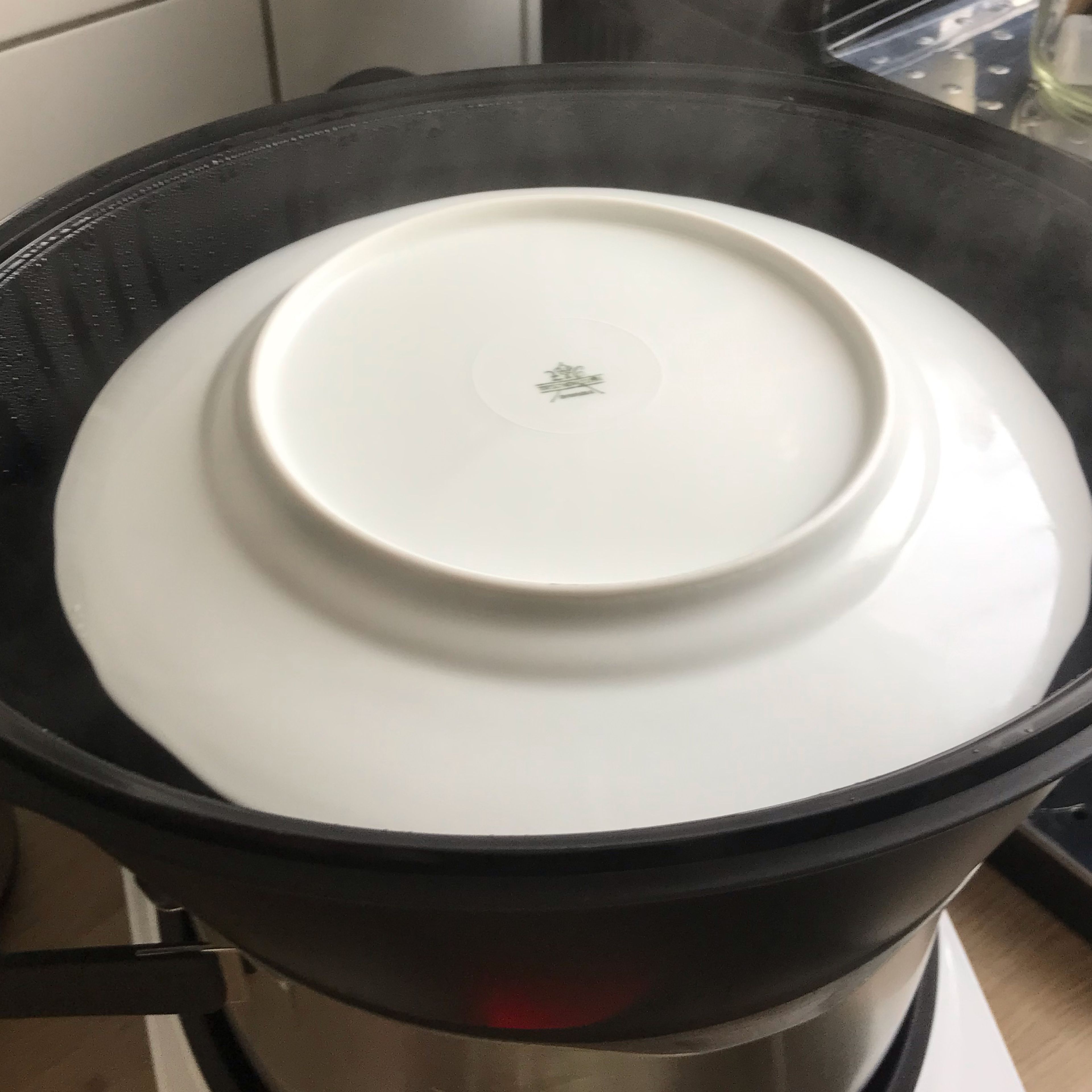 Ein Teller auf die Gläser legen, damit kein Wasser reintropft und Schokoküchlein dampfgaren (Automatikprogramm Dampfgaren | niedrige Intensität | 45 Min.).