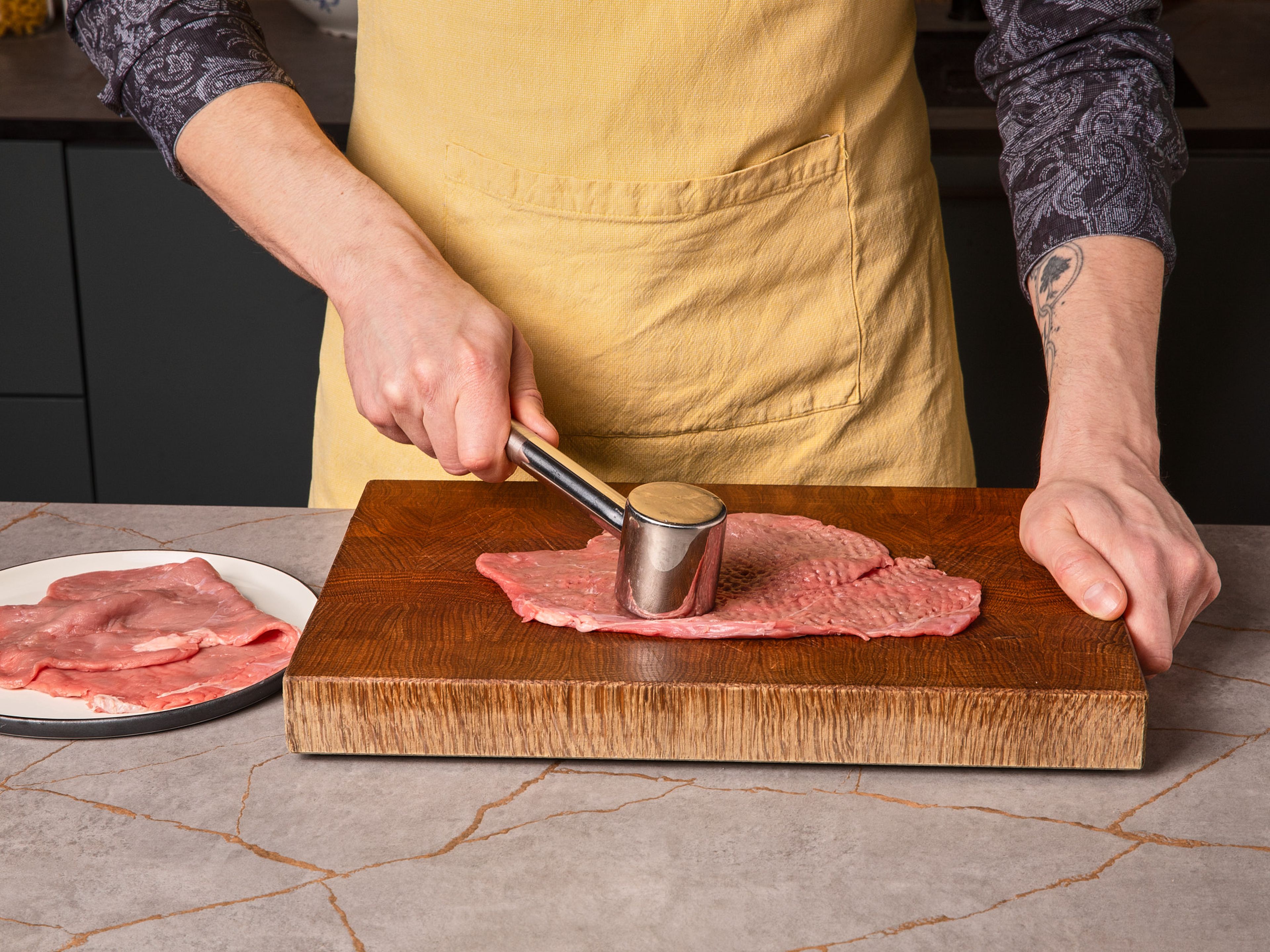 Das Kalbfleisch in ca. zwei Finger dicke Schmetterlingsstücke schneiden. Danach so dünn wie möglich klopfen, ohne Löcher zu verursachen.