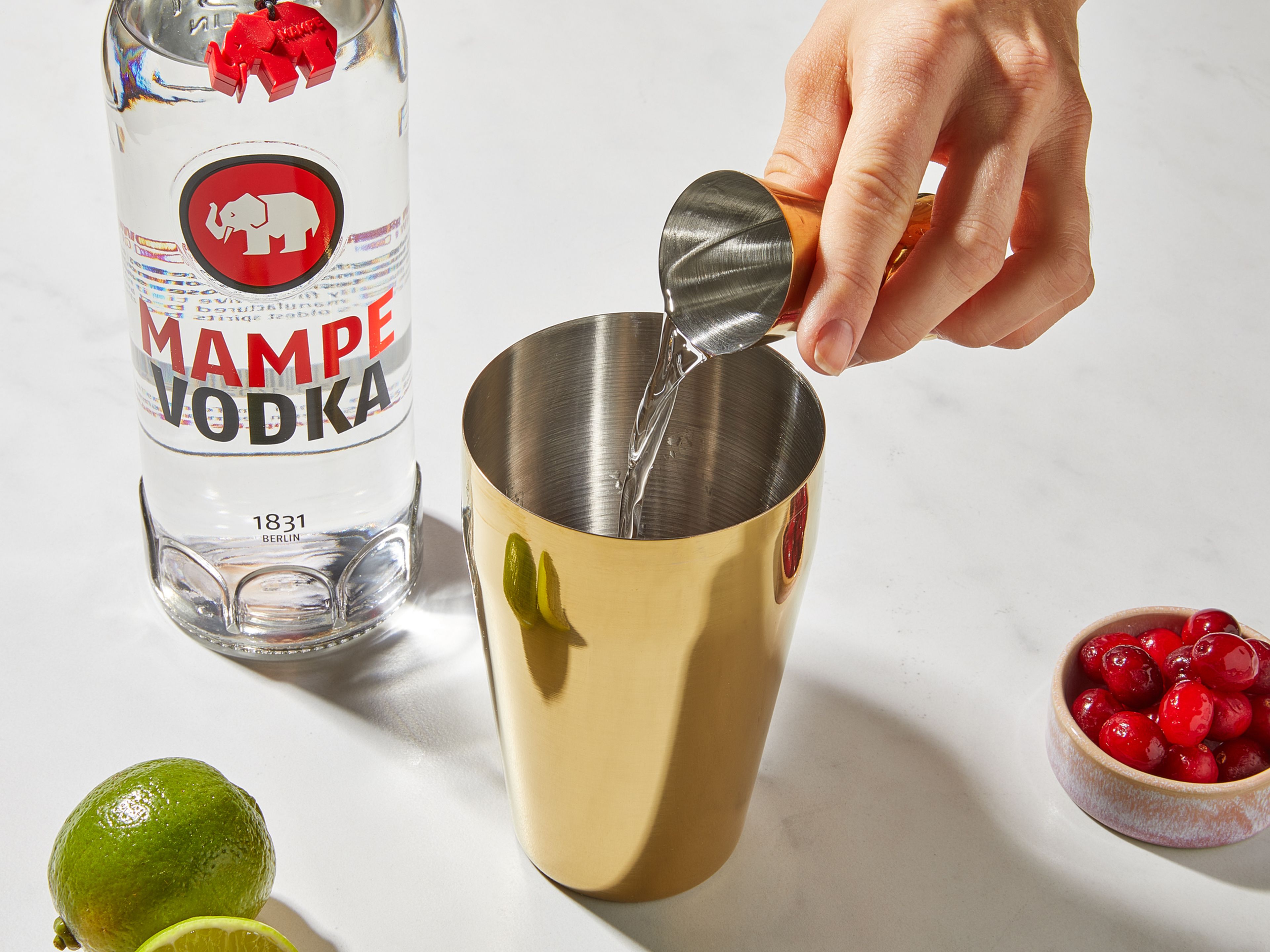 Frische Cranberries in einen Cocktailshaker geben, mit dem Stößel leicht zerdrücken. Die Limette halbieren, eine Scheibe abschneiden und die Hälfte einer Limette auspressen. Zusammen mit dem Cranberrysaft in den Shaker geben. Den Mampe Vodka hinzufügen, mit Eiswürfeln auffüllen und kräftig schütteln.