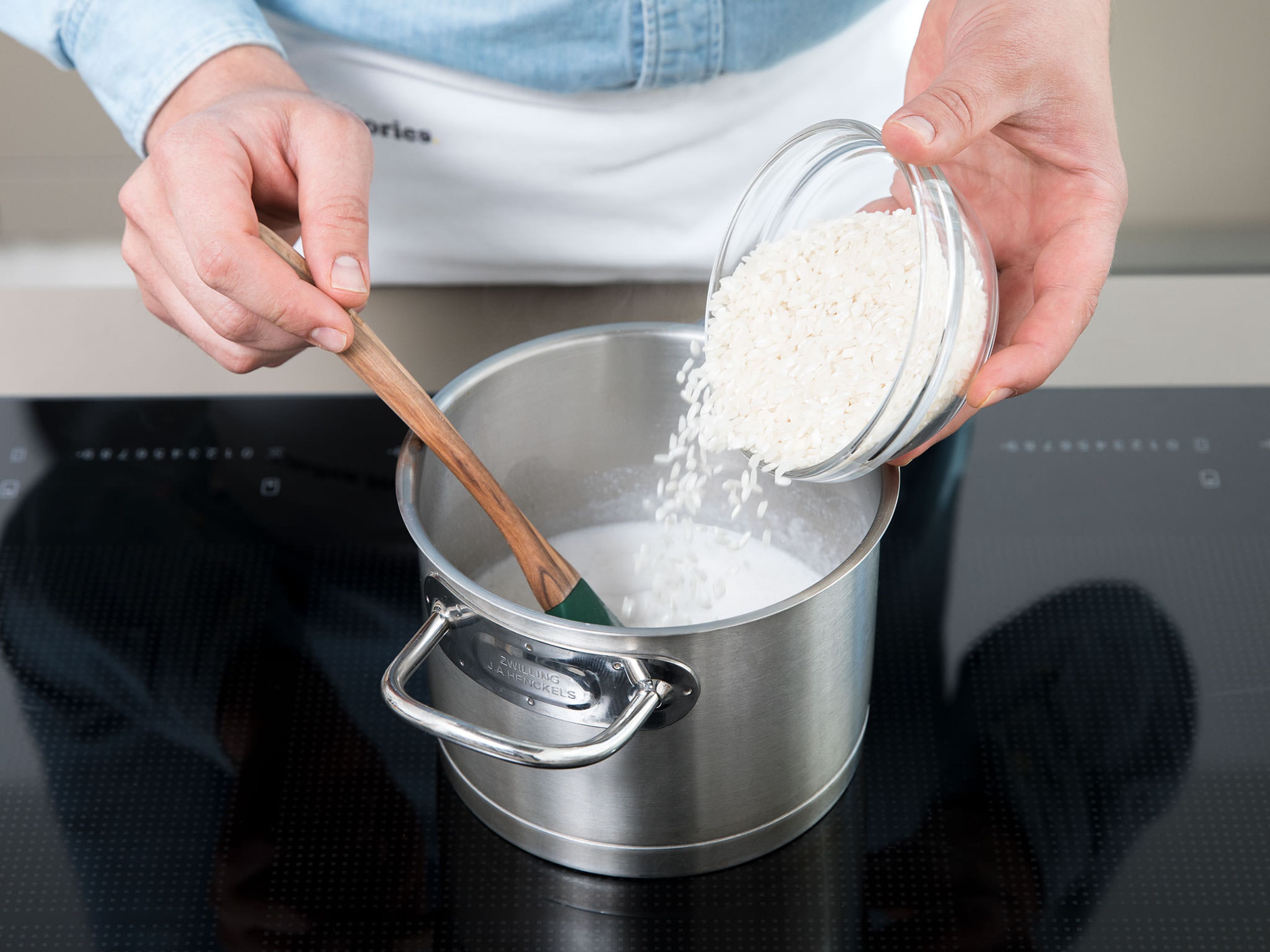 Den Reis ca. 15 Minuten lang in der Kokosmilch köcheln lassen. Dann die Milch hinzugeben und weitere 10 – 15 Min. köcheln lassen, bis der Reis eine cremige Konsistenz hat. Mehr Milch hinzugeben falls nötig. Gelegentlich rühren.