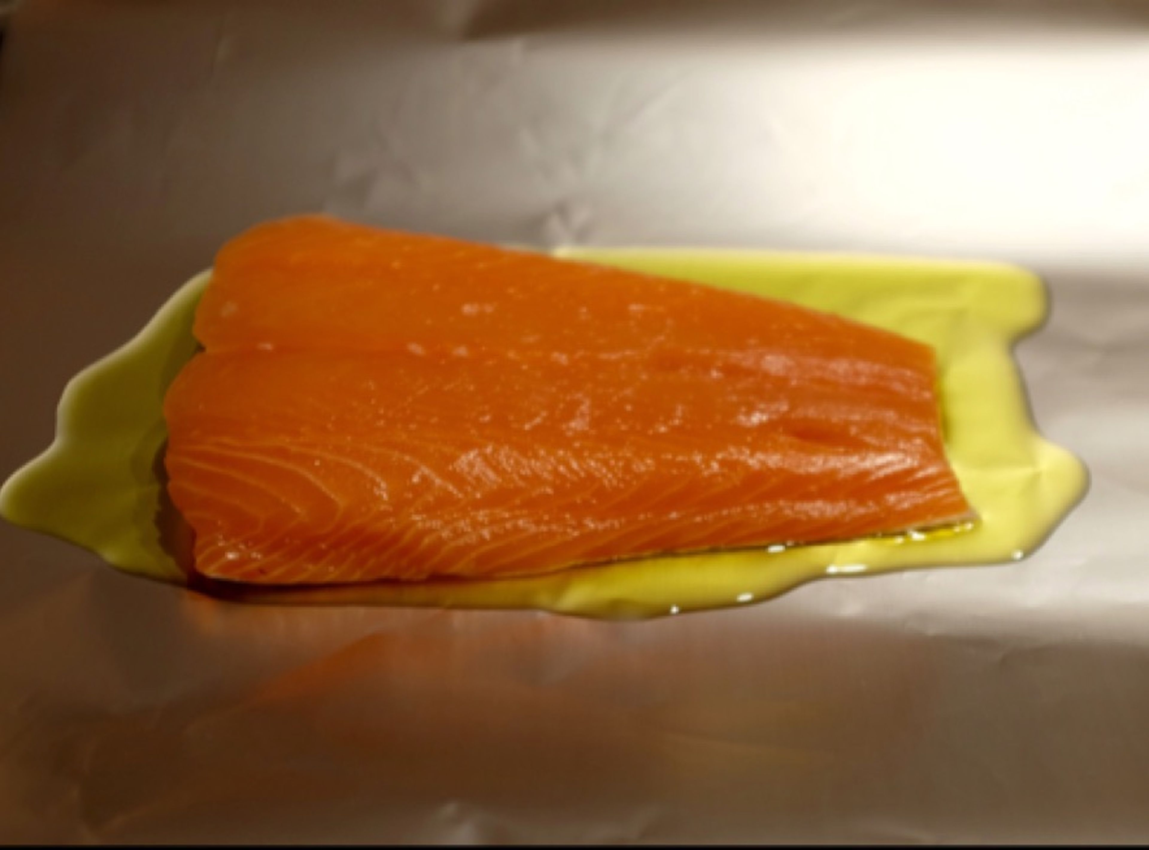 Preheat oven to 175°C/350°F. Line a baking sheet with one sheet of aluminum foil, drizzle the sheet with olive oil, and place salmon fillets on top.