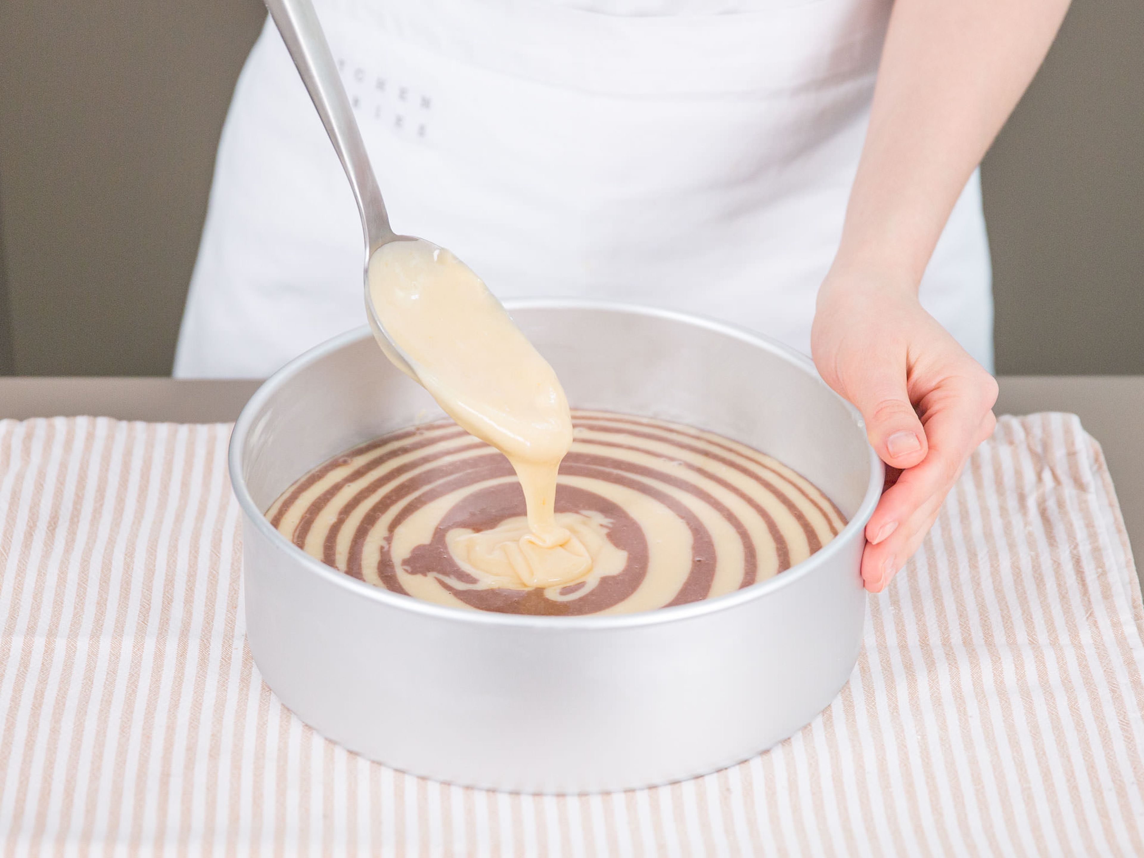 Transfer approx. half of batter to chocolate mixture and stir until combined and uniform. To create stripes, first spoon about 2 tablespoons of vanilla batter into center of cake pan. With a clean spoon, scoop same amount of chocolate batter directly onto center of vanilla batter. Continue alternating batters in this way until all of it is used. Bake for approx. 35 – 40  min., or until toothpick inserted into center of cake comes out clean. Let cake cool for 15 min. before turning out of pan. Let cool completely on cooling rack.