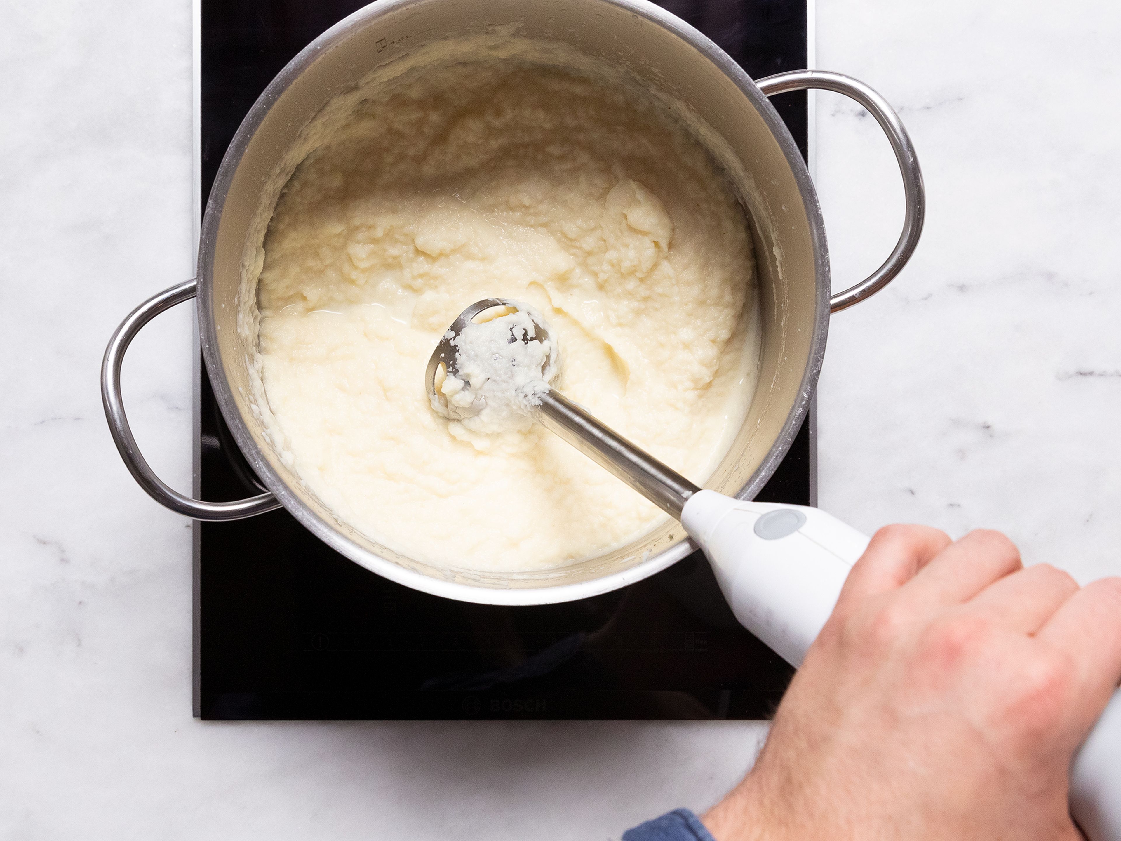Sahne und weiche Butter zu den Selleriewürfeln in den Topf geben und mit einem Stabmixer zu einem Püree verarbeiten. Mit Salz abschmecken und bis zum Servieren warm halten.