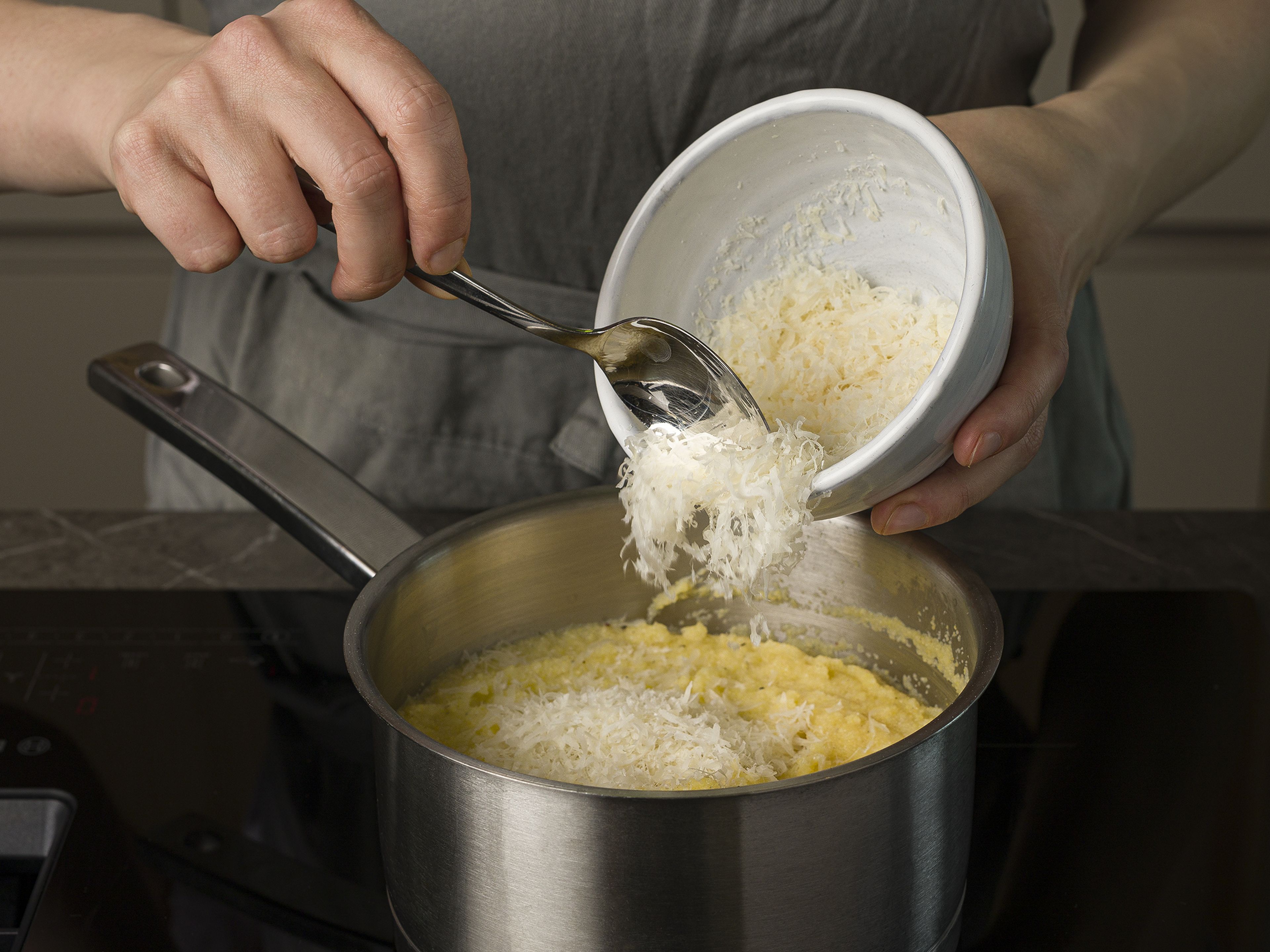 In a pot, heat olive oil over medium-high heat, then add the polenta. Add remaining veggie broth and let cook for approx. 2–4 min. while stirring vigorously. Mix with parmesan and remaining butter and season with salt and pepper. Serve polenta with veggies and more parmesan if desired.
